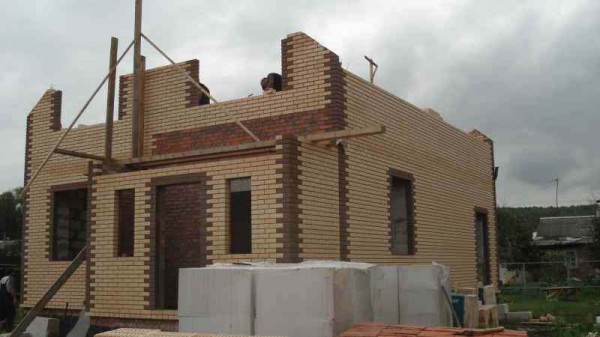 Face à une maison en béton cellulaire avec de la brique