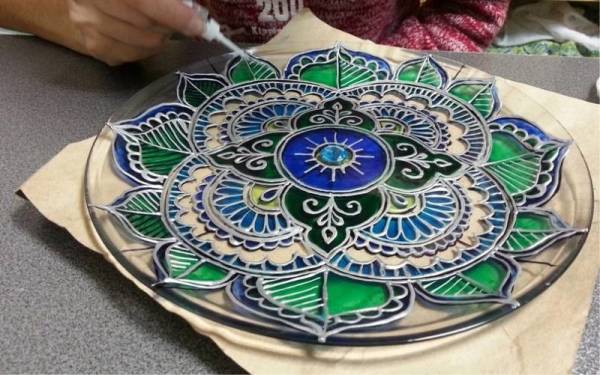 Le processus de peinture d'une plaque de verre avec des peintures de vitraux