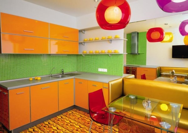 Orange kök med ljusa väggar och ett ljusgrönt förkläde