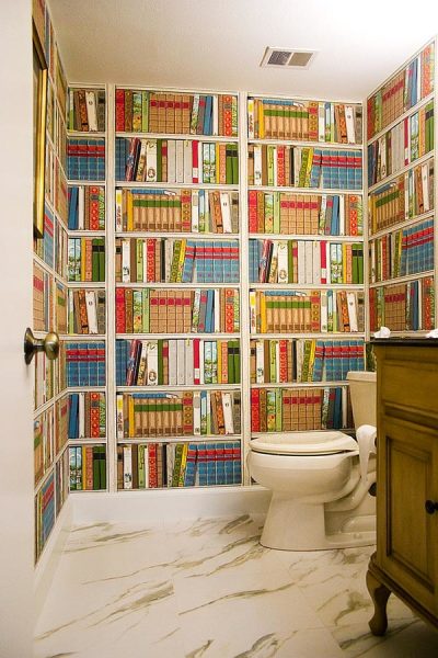 Mural dinding dengan gambar rak yang dipenuhi buku di bahagian dalam tandas