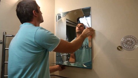 Kami melihat proses memasang cermin tanpa bingkai di dinding bilik mandi.